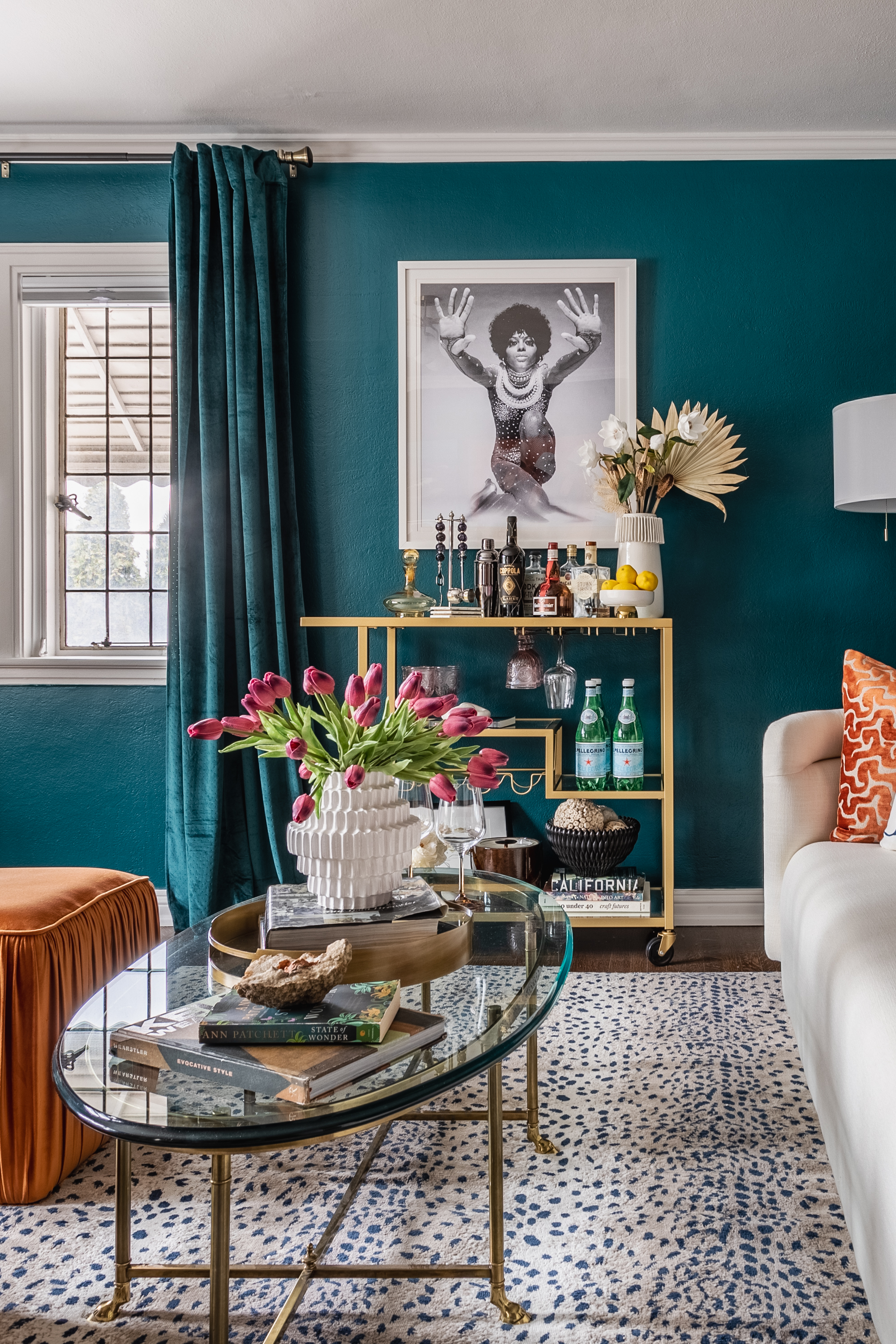 If you think every bedroom could benefit from a well-stocked bar cart, this space is for you. Hope G. Pace of So Chic Home Design & Staging designed it as the sitting area of a suite, with an emphasis on fabulosity. The orange ottoman and pillow liven up the teal (blue and orange are opposites on the color wheel) but they’re used judiciously so as not to make the space too energizing—it is a bedroom, after all. The glass top and open legs of the cocktail table keep the small space from feeling crowded.
